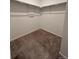 Empty walk-in closet features carpet, clothing rods, and overhead shelving at 6077 Caribou Dr, Brighton, CO 80601