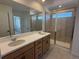 Modern bathroom with dual sinks, a large mirror, and a glass-enclosed shower, offering a luxurious feel at 7243 Prairie Sage Ln, Littleton, CO 80125