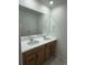 Contemporary bathroom featuring a double vanity, modern fixtures, and a large mirror at 7243 Prairie Sage Ln, Littleton, CO 80125