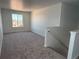Spacious loft area with neutral carpet, a bright window, and access to the upper level staircase at 7243 Prairie Sage Ln, Littleton, CO 80125