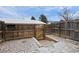 Fenced backyard with a wooden gate and concrete steps leading to a lower level with rock landscaping at 13993 E Jewell Ave, Aurora, CO 80012