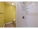 Tiled shower with shelving and fixtures, plus a connected toilet room in a bright bathroom at 13993 E Jewell Ave, Aurora, CO 80012