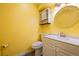 Bright half bathroom featuring a round mirror, cabinet lighting, and sleek fixtures at 13993 E Jewell Ave, Aurora, CO 80012