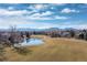 Picturesque aerial view showcasing a tranquil lake and golf course nestled within a residential community at 538 Fairfield Ln, Louisville, CO 80027