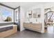 Elegant bathroom featuring dual sinks, a soaking tub, and a large window providing ample natural light at 538 Fairfield Ln, Louisville, CO 80027