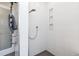 Modern bathroom shower featuring white tile, built-in shelving, and a sleek shower head at 538 Fairfield Ln, Louisville, CO 80027