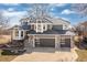 Stunning two-story home with a meticulously kept lawn, gray exterior, stone accents, and a three-car garage at 538 Fairfield Ln, Louisville, CO 80027