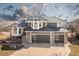Stunning two-story home with a meticulously kept lawn, gray exterior, stone accents, and a three-car garage at 538 Fairfield Ln, Louisville, CO 80027