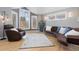 Spacious living room featuring unique leather furniture, hardwood floors, and ample natural light from large windows at 538 Fairfield Ln, Louisville, CO 80027