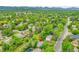 An aerial view showcasing the property among a neighborhood filled with trees and mountain views at 7439 S Depew St, Littleton, CO 80128