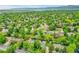 An aerial view showcasing the property among a neighborhood filled with trees, and in the distance, a lake at 7439 S Depew St, Littleton, CO 80128