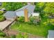 Backyard view featuring lush green grass, a brick chimney, an above garage patio, and a garden at 7439 S Depew St, Littleton, CO 80128