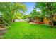 Large, lush backyard with mature trees, featuring a covered patio and storage shed at 7439 S Depew St, Littleton, CO 80128
