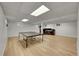 Spacious finished basement area with light wood floors, a ping pong table, and a work station at 7439 S Depew St, Littleton, CO 80128