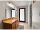 Well-lit bathroom featuring granite countertops, a mirror, and tile flooring at 7439 S Depew St, Littleton, CO 80128
