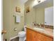 Powder room featuring a granite countertop vanity, flower art, a mirror, and tile flooring at 7439 S Depew St, Littleton, CO 80128