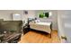 Bedroom featuring a dark wood frame bed, nightstand, hardwood floors, and a sunny window at 7439 S Depew St, Littleton, CO 80128