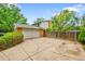 Driveway to a garage with a fenced yard, showcasing the side and back exterior of the property at 7439 S Depew St, Littleton, CO 80128