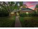 Charming brick home with mature landscaping and a sidewalk leading to the front door at 7439 S Depew St, Littleton, CO 80128