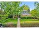 Charming brick home with mature landscaping and a sidewalk leading to the front door at 7439 S Depew St, Littleton, CO 80128