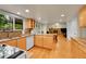 Functional kitchen featuring an island, wooden cabinetry, and hardwood flooring at 7439 S Depew St, Littleton, CO 80128