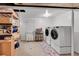 Bright laundry room featuring modern washer/dryer units and shelving for storage at 7439 S Depew St, Littleton, CO 80128