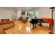 Bright living room featuring a piano, hardwood floors, and comfortable seating arrangement at 7439 S Depew St, Littleton, CO 80128