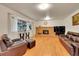 Comfortable living room features a brick fireplace, large windows, and hardwood flooring at 7439 S Depew St, Littleton, CO 80128