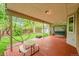 Covered patio area featuring a picnic table and a cushioned swing, surrounded by a lush yard at 7439 S Depew St, Littleton, CO 80128