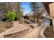 View of the backyard with a stone patio, fire pit, and mature landscaping at 2111 E Alameda Ave, Denver, CO 80209