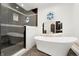 Luxurious bathroom featuring a soaking tub, sleek glass enclosed shower, and unique round windows at 2111 E Alameda Ave, Denver, CO 80209