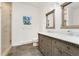 Bathroom features a double vanity, shower, and stone tile flooring at 2111 E Alameda Ave, Denver, CO 80209