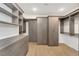 Spacious walk-in closet with custom shelving, cabinets, drawers, and hardwood floors at 2111 E Alameda Ave, Denver, CO 80209