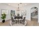 Bright dining room with gray chairs, chandelier, hardwood floors, and view from the window at 2111 E Alameda Ave, Denver, CO 80209