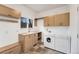 Laundry room with washer, dryer, sink, wood cabinets, and window at 2111 E Alameda Ave, Denver, CO 80209