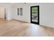 Bright room with hardwood floors, a window, a black door to the patio, and neutral white walls at 2111 E Alameda Ave, Denver, CO 80209