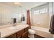 Well-lit bathroom features a shower-tub combo with tile surround and a dark wood vanity at 350 N Langdale Ct, Aurora, CO 80018