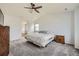 Bright, carpeted main bedroom featuring a ceiling fan, ensuite bath and walk-in closet at 350 N Langdale Ct, Aurora, CO 80018