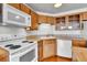 Kitchen with white appliances, wood cabinets, and laminate countertops at 1301 Speer Blvd # 1008, Denver, CO 80204