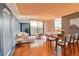 Bright living room featuring wood floors, a modern sofa, and a dining area with city views at 1301 Speer Blvd # 1008, Denver, CO 80204