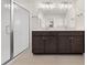 Modern bathroom with double vanity, decorative lighting, and glass-enclosed shower at 21134 E 63Rd Dr, Aurora, CO 80019
