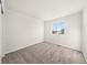 A bright bedroom featuring neutral carpet, white walls, and a window with views at 21134 E 63Rd Dr, Aurora, CO 80019