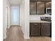 Hallway entrance to kitchen with dark brown cabinets and stainless steel appliances at 21134 E 63Rd Dr, Aurora, CO 80019