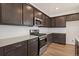 Modern kitchen featuring stainless steel appliances, white subway tile, and dark cabinets at 21134 E 63Rd Dr, Aurora, CO 80019