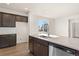 Bright kitchen with stainless steel appliances, kitchen island and dark brown cabinetry at 21134 E 63Rd Dr, Aurora, CO 80019
