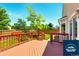 Wood deck with a red railing overlooks a green backyard with mature trees at 5720 S Tempe Ct, Aurora, CO 80015