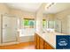 Bright bathroom with large vanity, soaking tub, and glass-enclosed shower at 5720 S Tempe Ct, Aurora, CO 80015