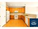 Kitchen with appliances, light wood cabinetry, and laminate countertops at 5720 S Tempe Ct, Aurora, CO 80015