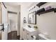 Bathroom featuring a vanity, a mirror, a toilet, shelves, and a door at 9713 W Chatfield Ave # H, Littleton, CO 80128