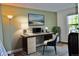 Home office features a modern desk setup with a chair, lamp, art and a window at 9713 W Chatfield Ave # H, Littleton, CO 80128